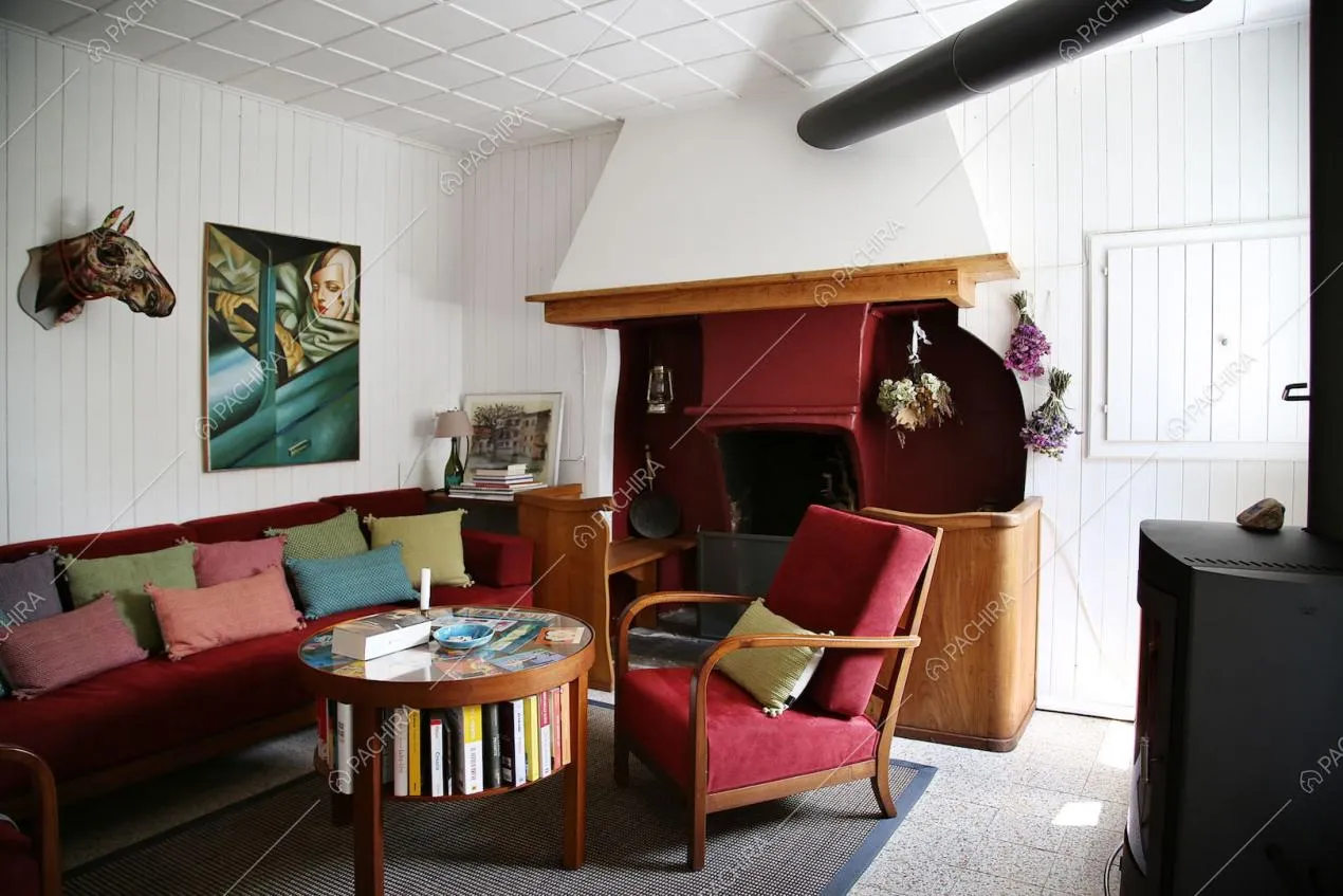 Zona living con divano, poltrona e camino rossi