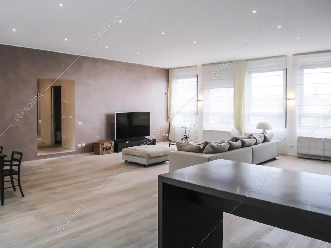 Inquadratura più ampia della zona living vista dalla scrivania nera e scorcio sul corridoio
