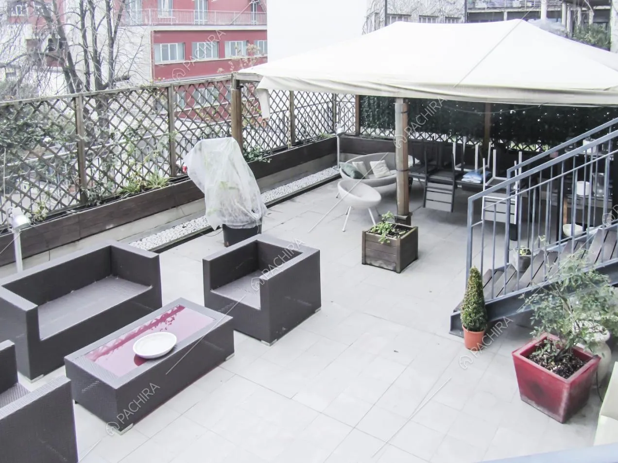Vista dall'alto sulla terrazza con salottino, gazebo e tavolo da pranzo
