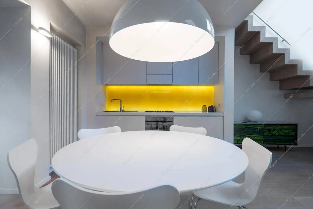 Cucina a vista e tavolo da pranzo bianco