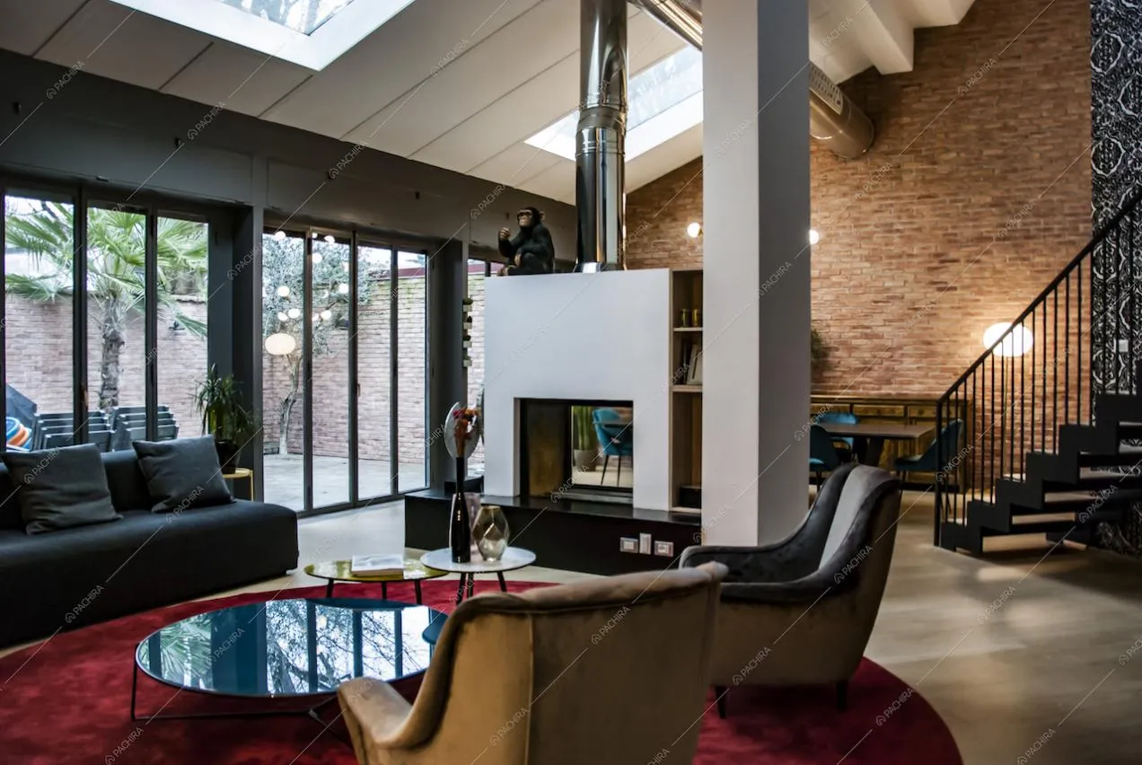 Loft con vetrate, camino e parete in mattoni rossi