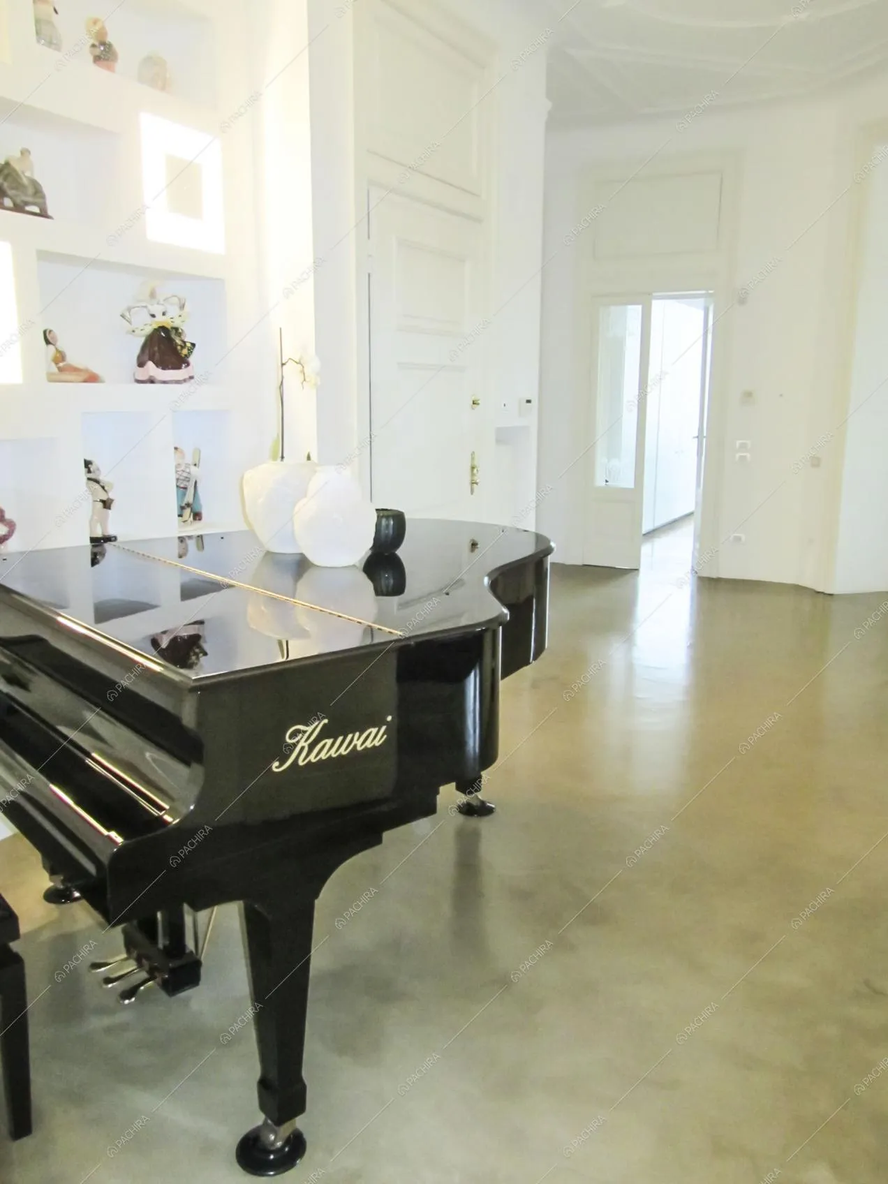 Pianoforte nel corridoio con pavimento in resina e boiserie alle pareti bianche