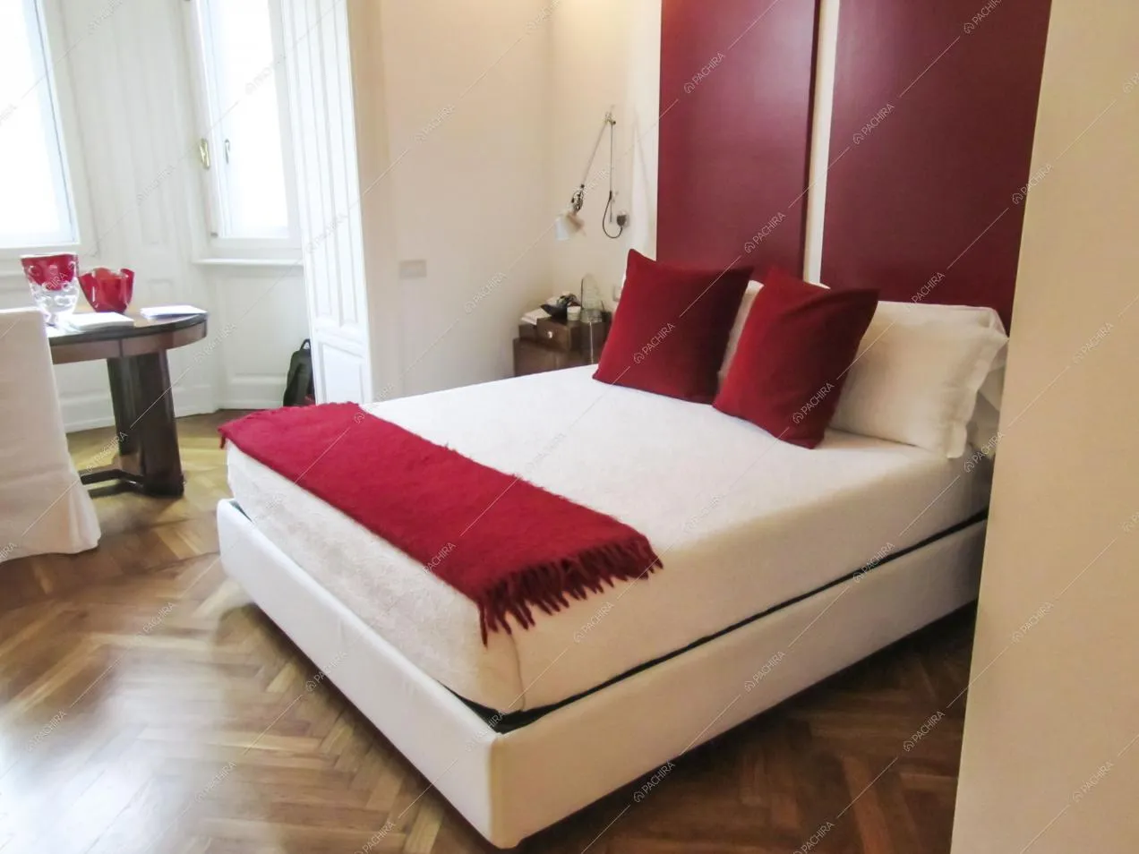 Camera da letto matrimoniale con pavimento in parquet a spina di pesce e scrivania