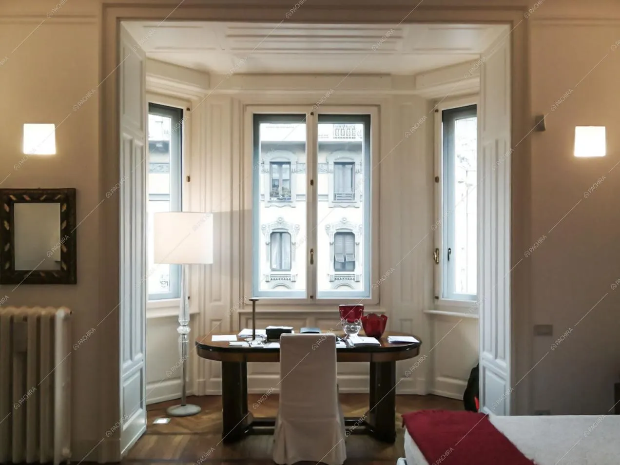 Scrivania nella camera da letto matrimoniale con boiserie alle pareti bianche