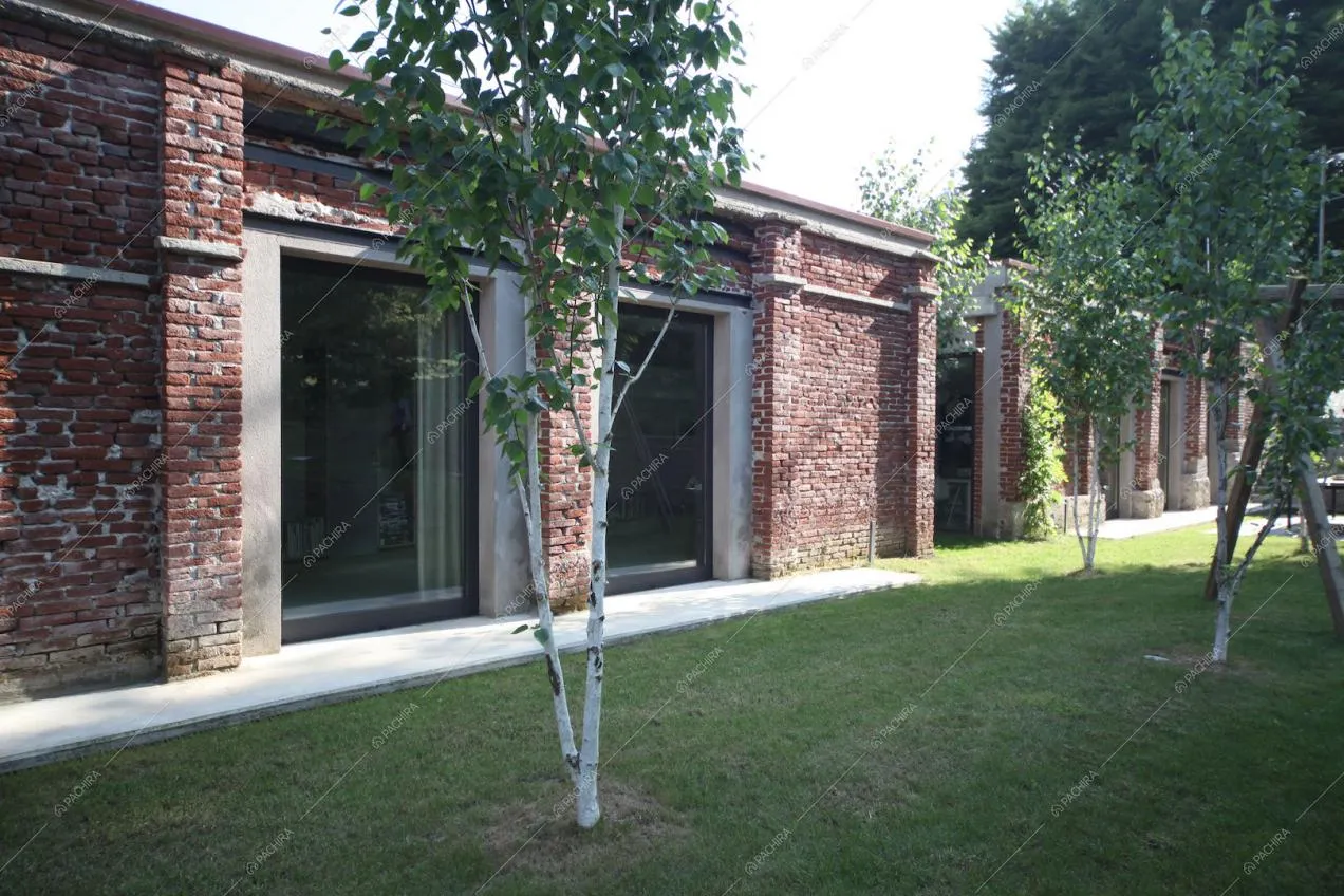 Pareti in mattoni, vetrate e giardino