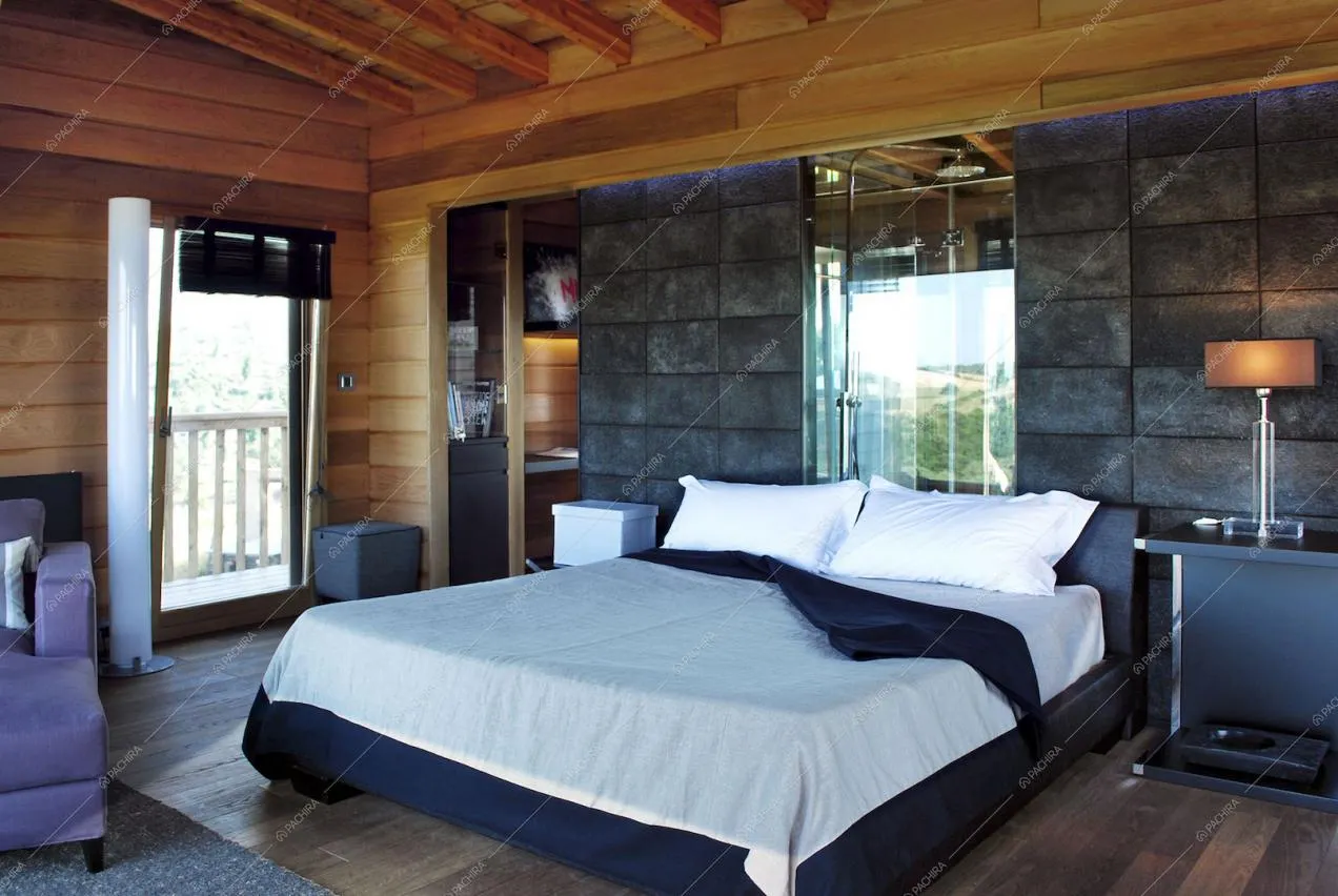 Camera con letto matrimoniale e soffitto con travi a vista