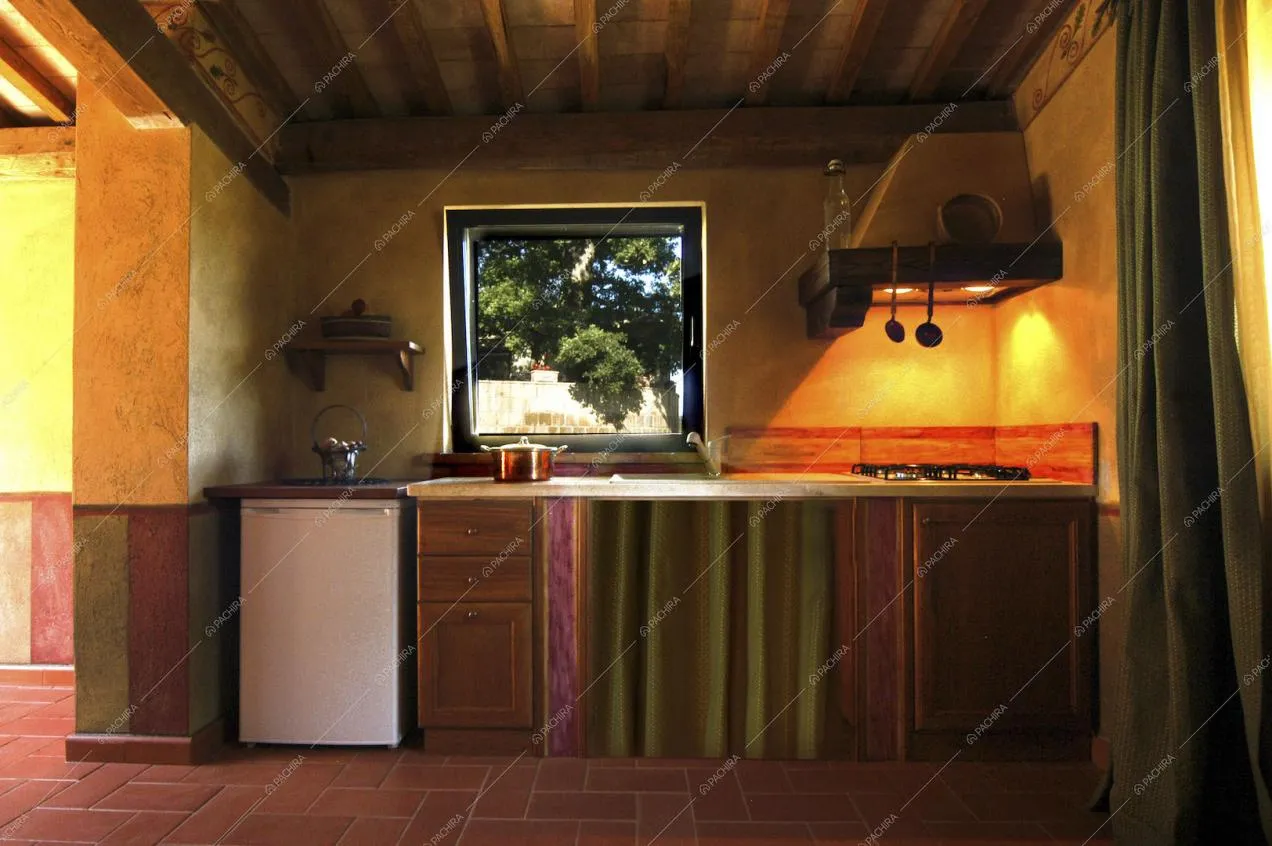 Cucina a parete con travi a vista e fornelli a gas