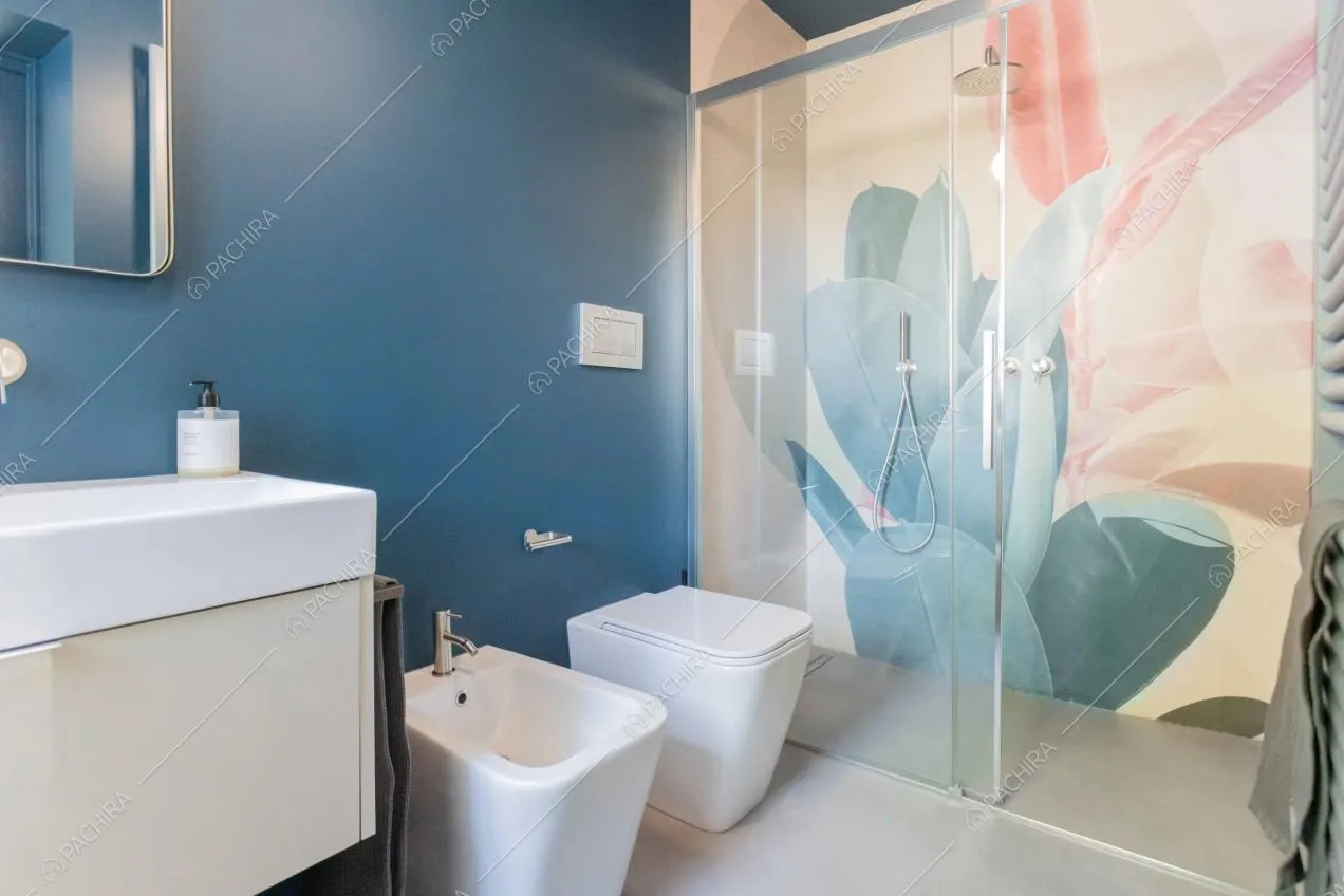 Bagno con box-doccia, dalle pareti blu e con carta da parati a fantasia floreale