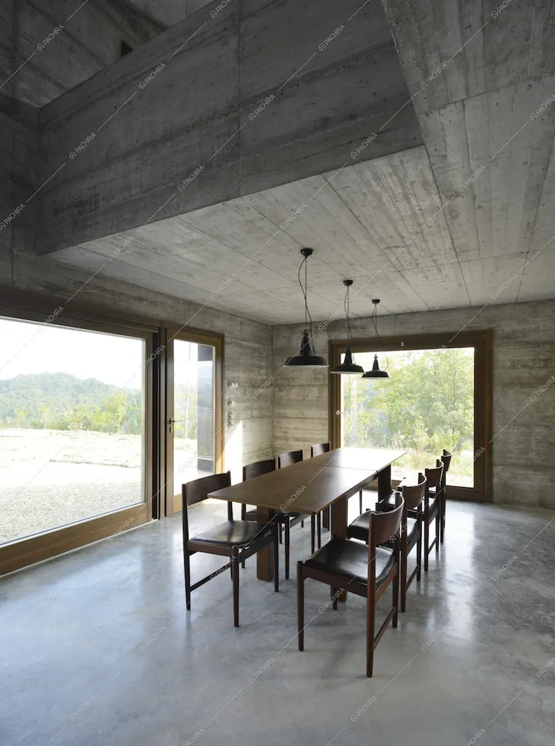 Zona pranzo con tavolo in legno da otto posti e vetrate