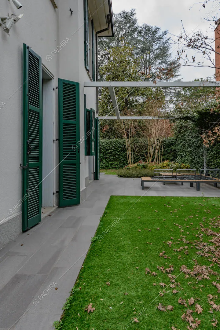 Giardino e vista sugli esterni bianchi con persiane verdi della location