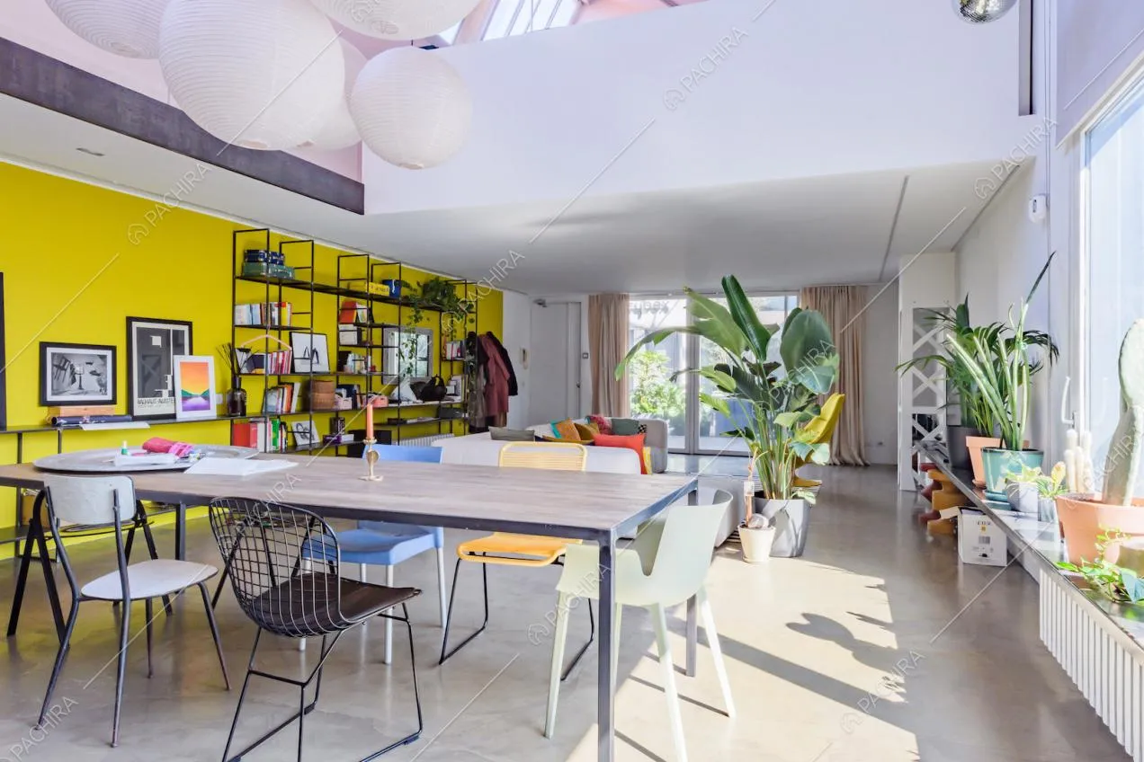 Luminosa zona living con tavolo da pranzo e vista sul parapetto del soppalco