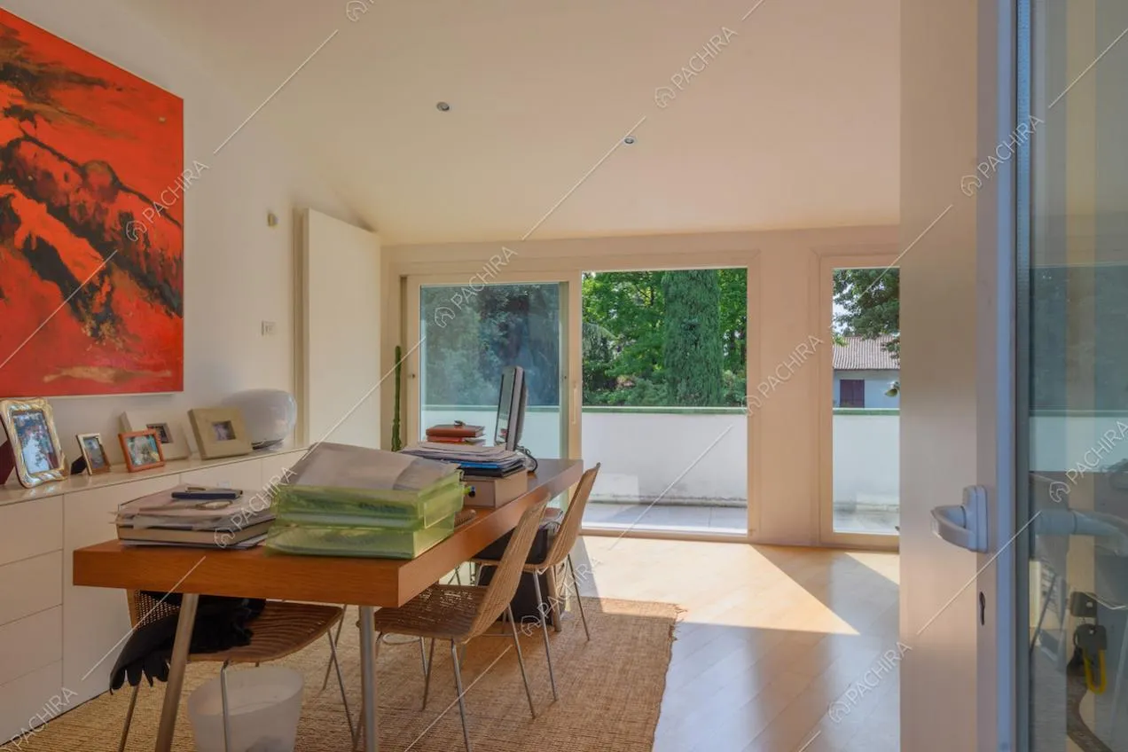 Scrivania in legno nella stanza con pavimento in parquet e vetrate