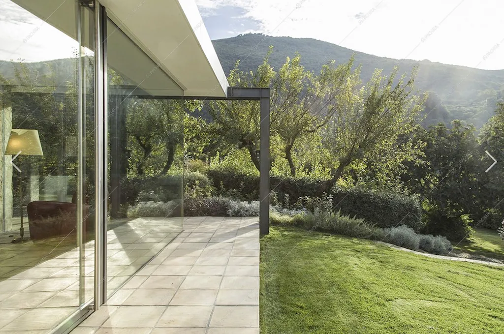 Il rigoglioso giardino e le vetrate della villa