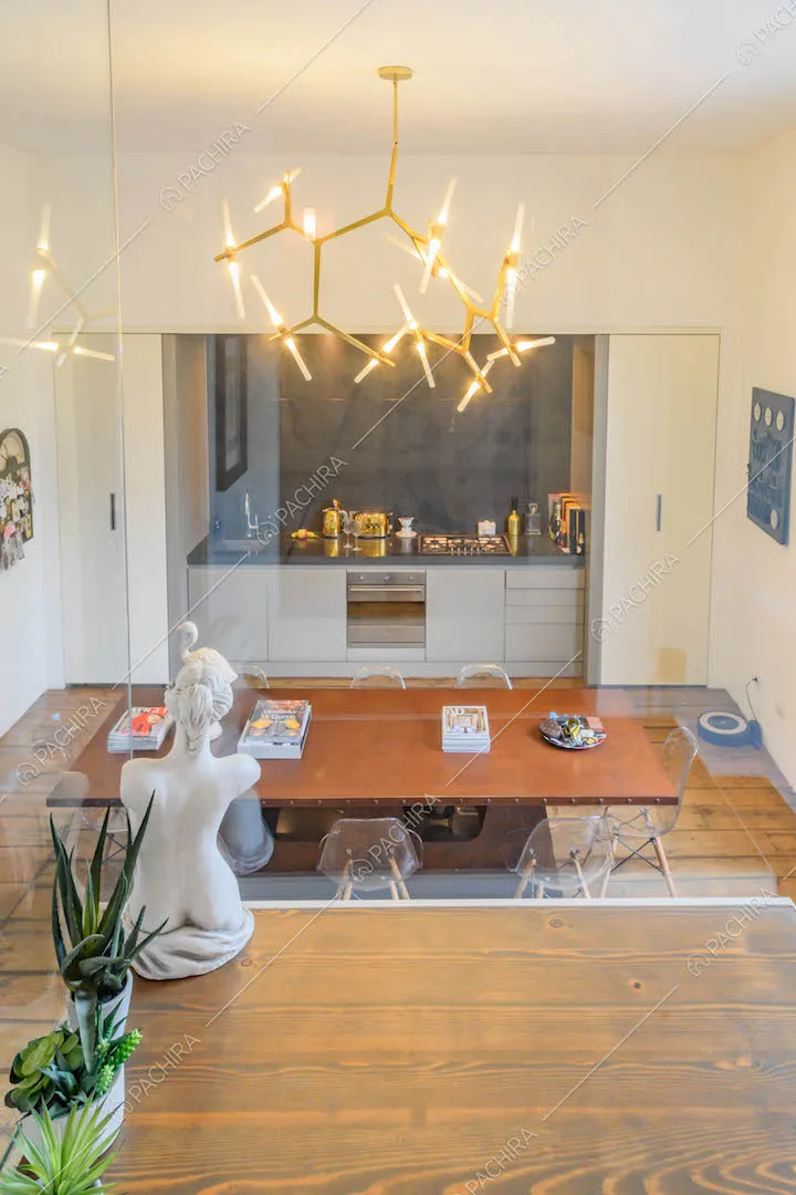 Pavimento in parquet sul soppalco con pareti in vetro e vista sulla cucina