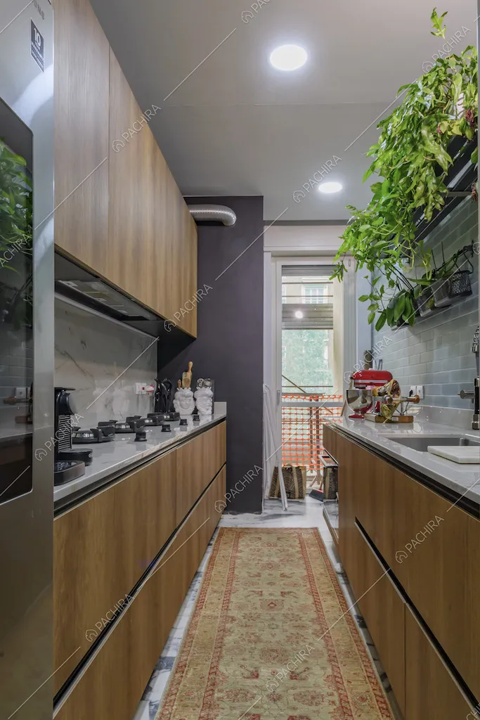 Cucina a muro che si sviluppa per il lungo, con fornelli a gas e piano da lavoro in marmo