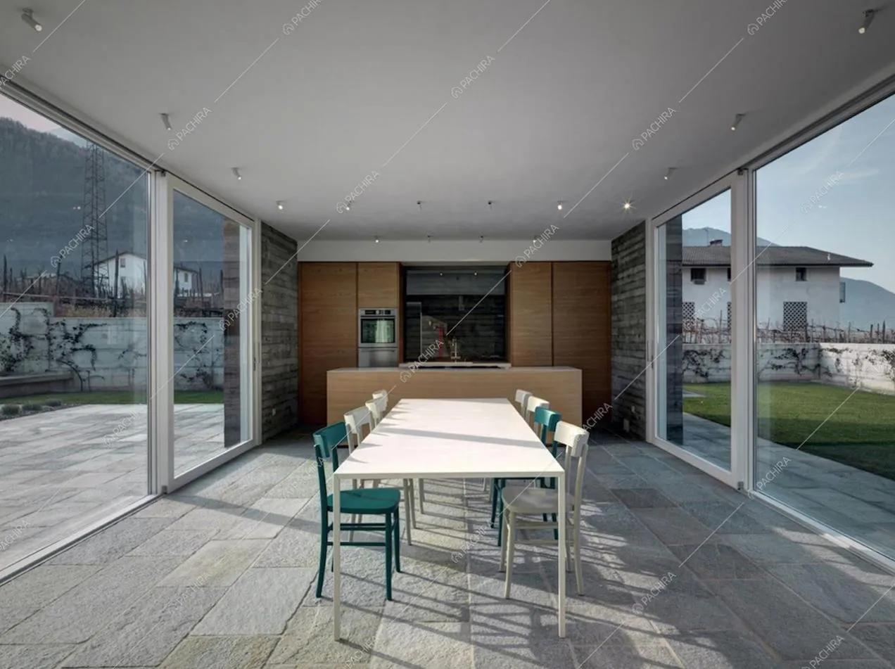 Tavolo da pranzo e le vetrate luminose della Villa