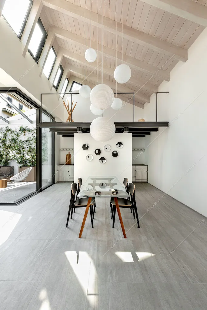 Sala con tavolo da pranzo, cucina parzialmente a vista e pareti bianche