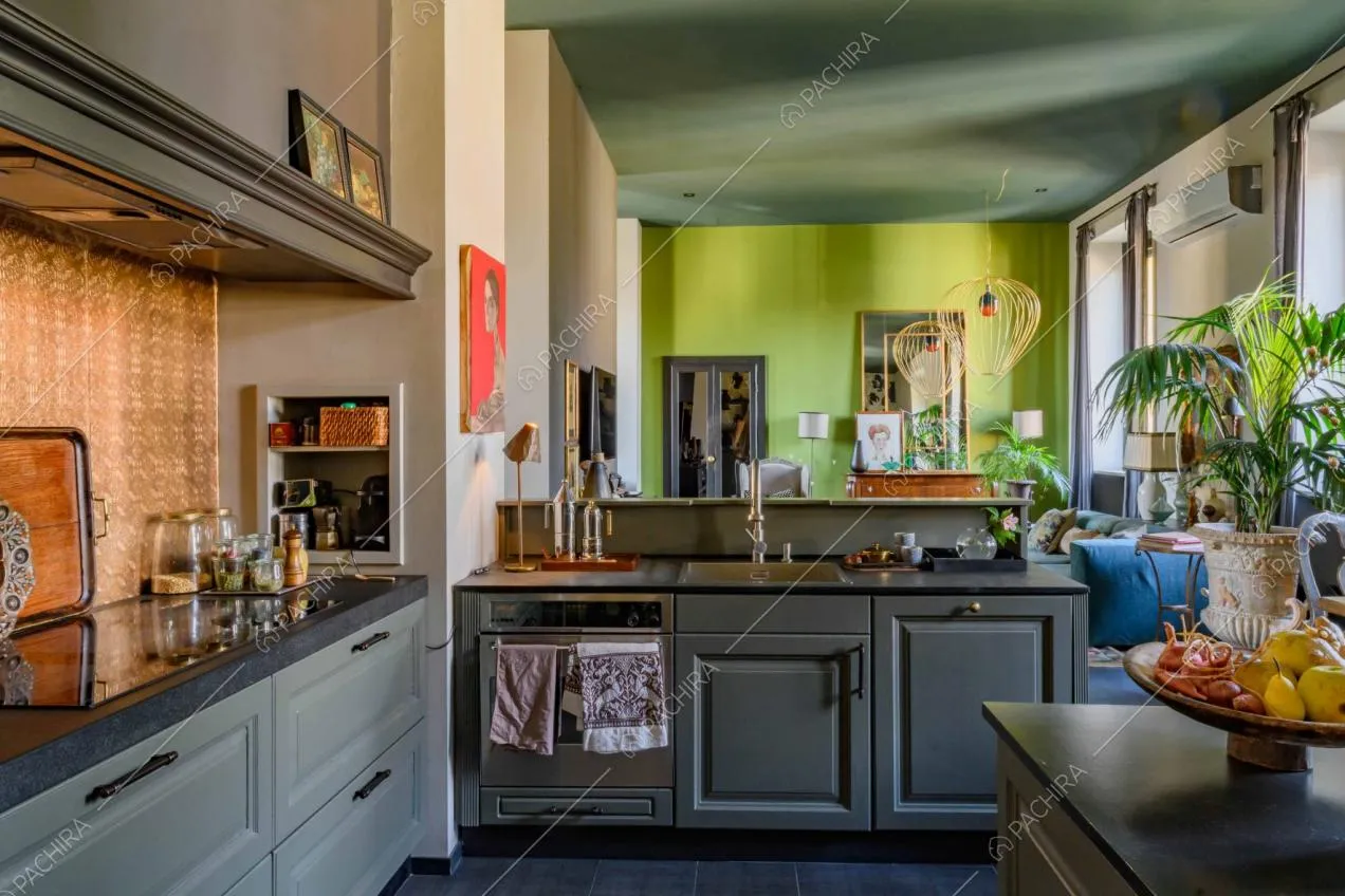 Fornelli a induzione nella cucina con soffitto blu petrolio e parete della sala verde acido