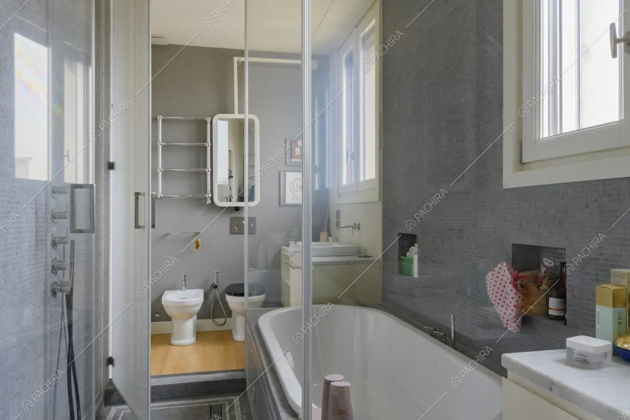 Dall'area con vasca e doccia separate da parete in vetro, vista sui sanitari
