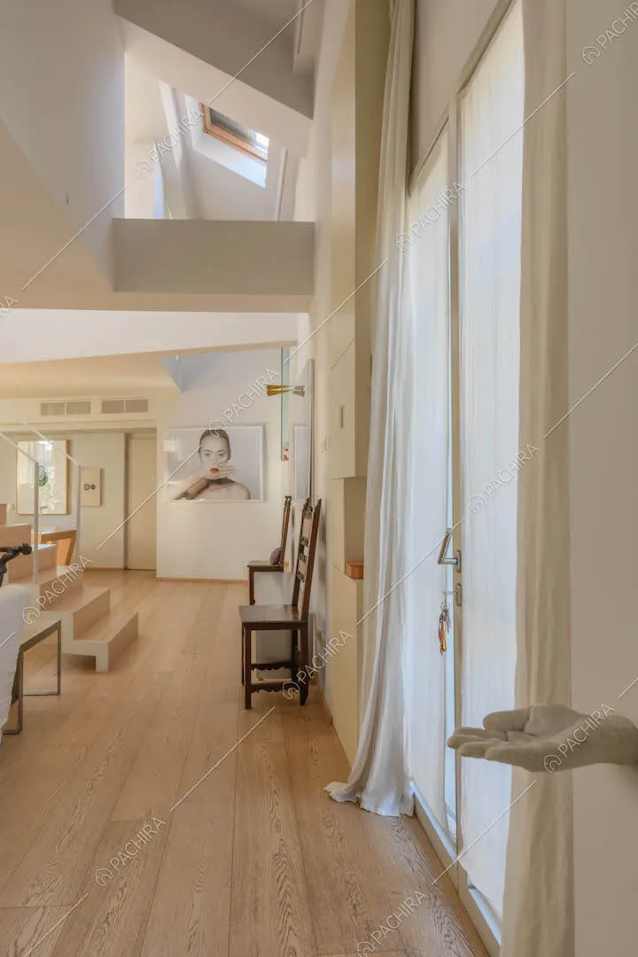Grande sala con pavimento in parquet, porta-finestra e lucernari