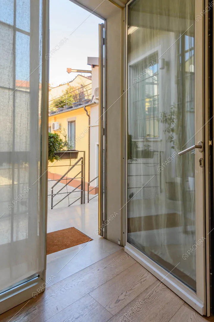 Dal salotto con pavimento in parquet accesso al cortile tramite la porta-finestra