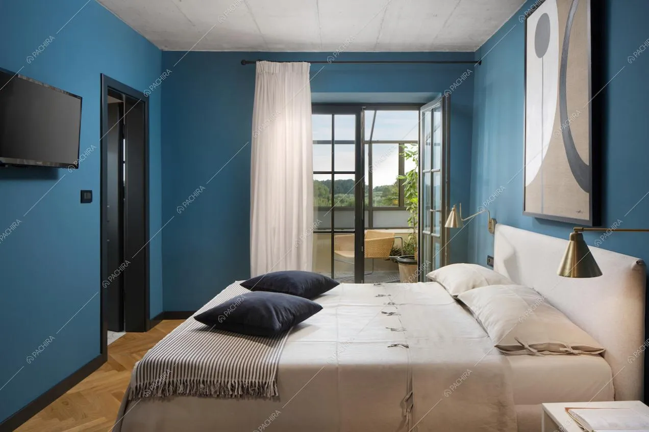 Camera da letto con pareti azzurre e ampie finestre