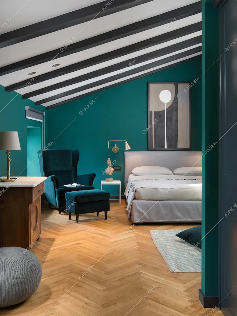 Travi a vista, parquet e poltrona color ottanio