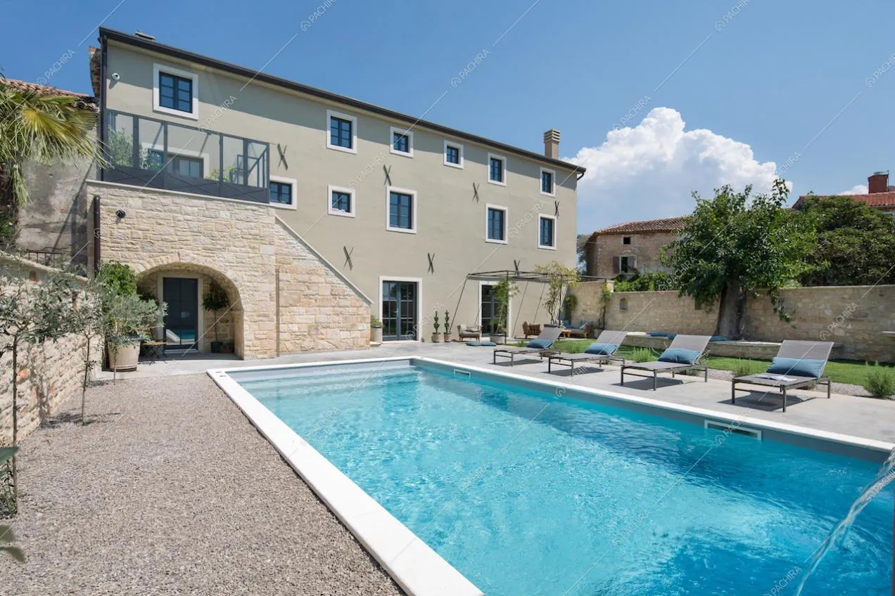 Vista della cascina ristrutturata in villa moderna e della piscina