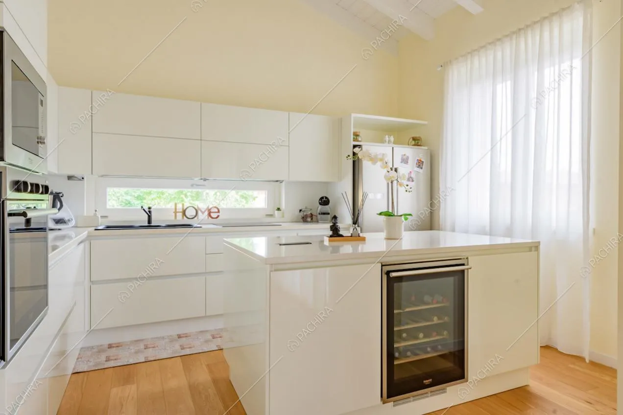 Luminosa cucina a isola con fornelli a induzione e pavimento in parquet