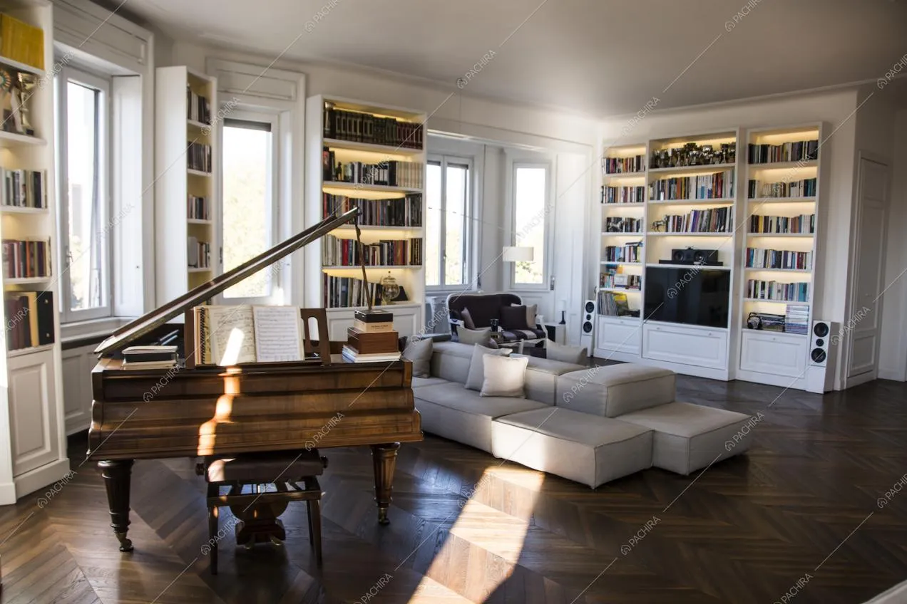 Il salotto della Location Lime: pianoforte, librerie e divani