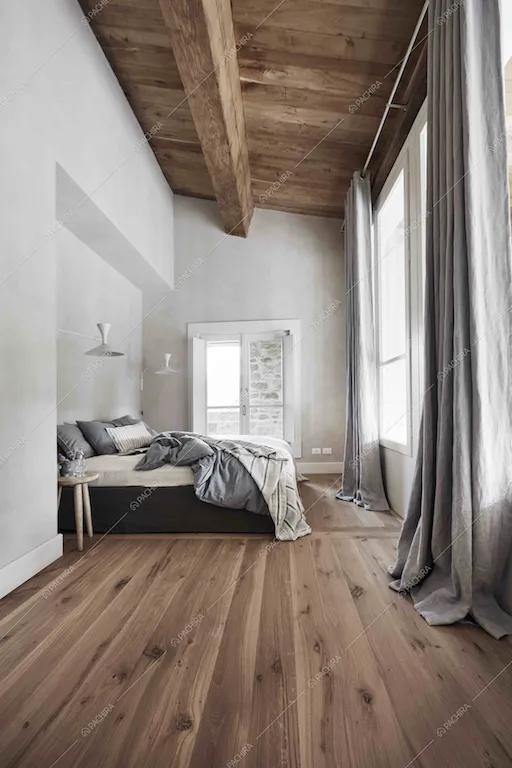 Travi a vista e pavimento in parquet nella camera da letto