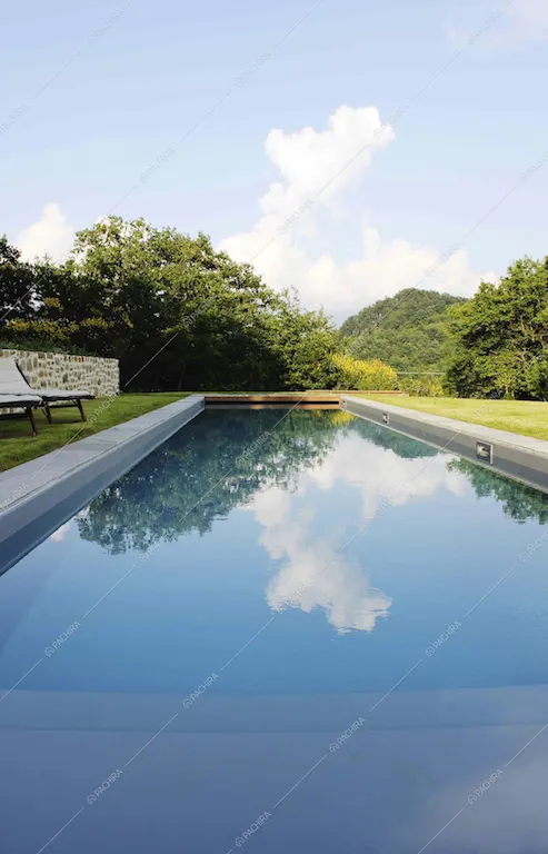La grande piscina all'aperto immersa nel verde
