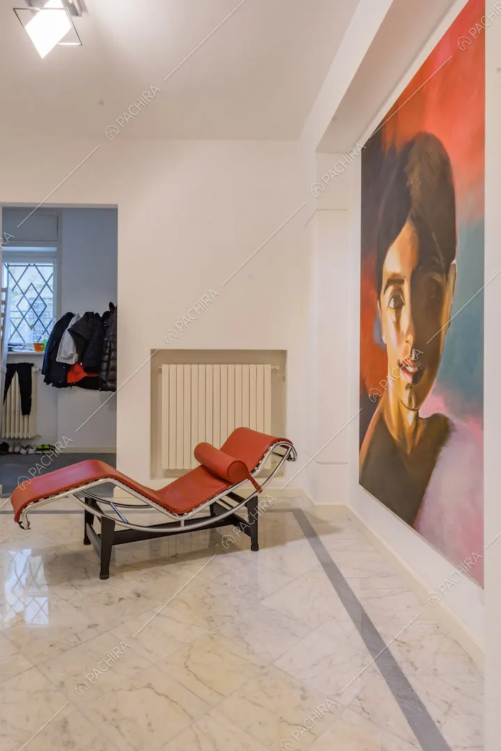 Pavimento in marmo bianco nell'atrio con chaise longue rossa