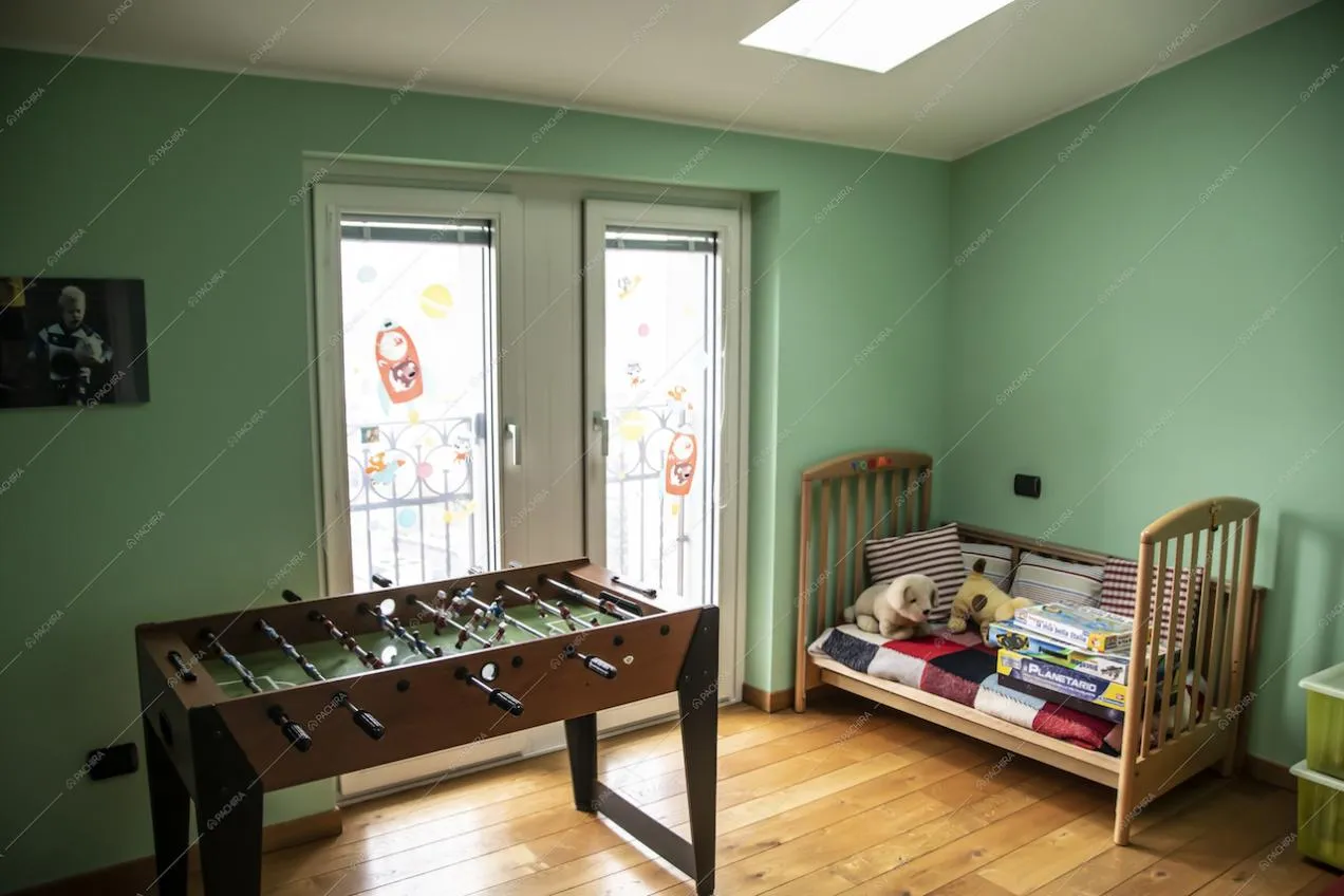 La camera dei bambini con soffitto a mansarda e un calcetto