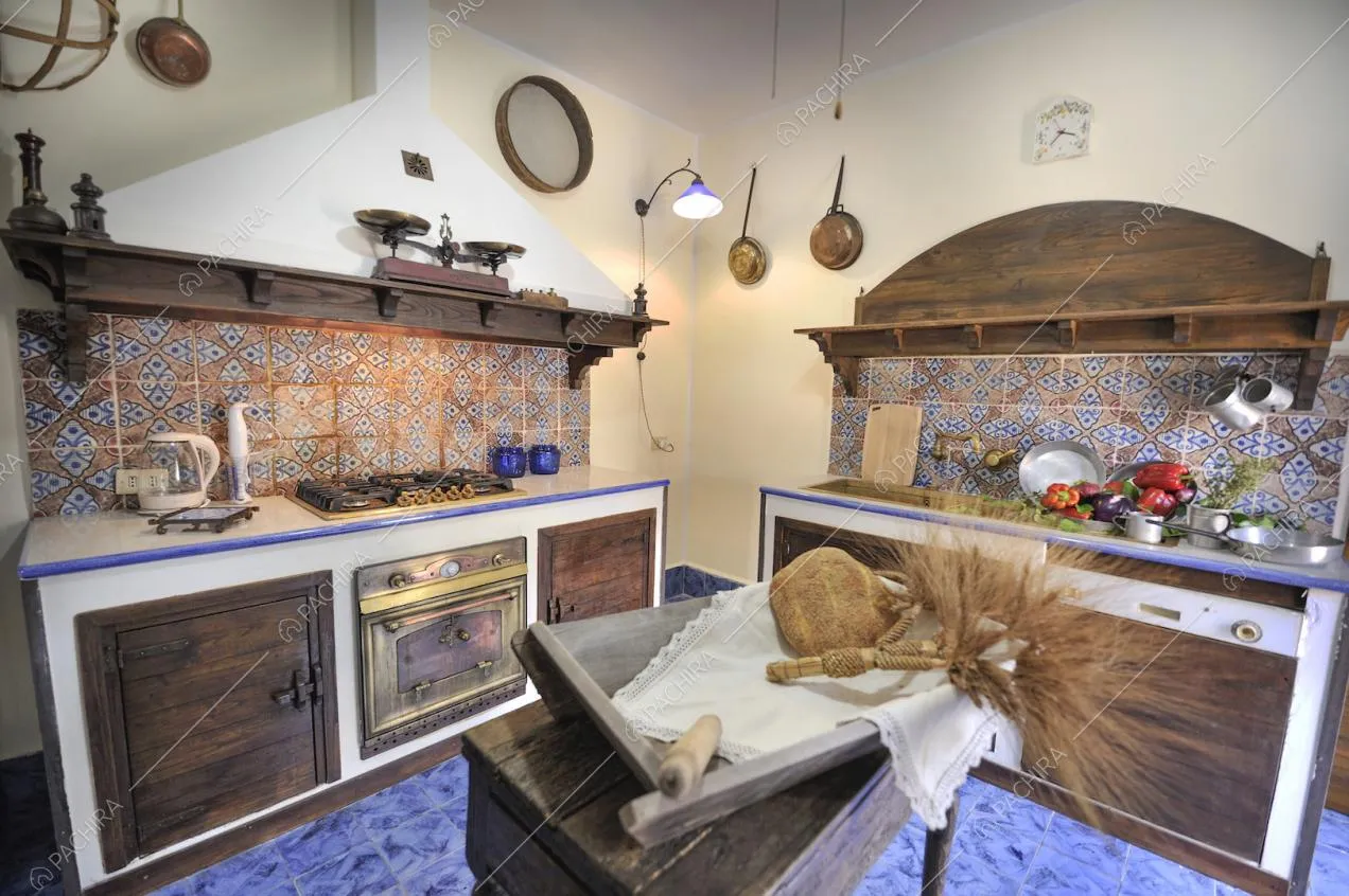 Cucina d'epoca con arredi in legno, maioliche e pavimento con piastrelle blu