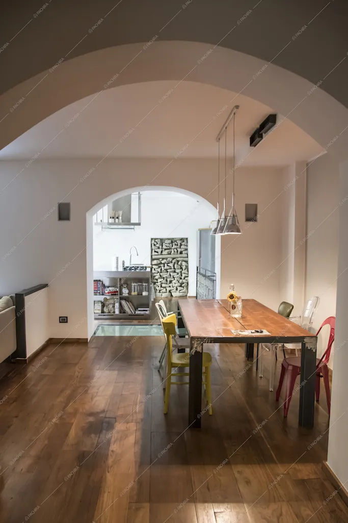 Dalle volte ad arco della Location Carota si intravede la sala da pranzo e la cucina