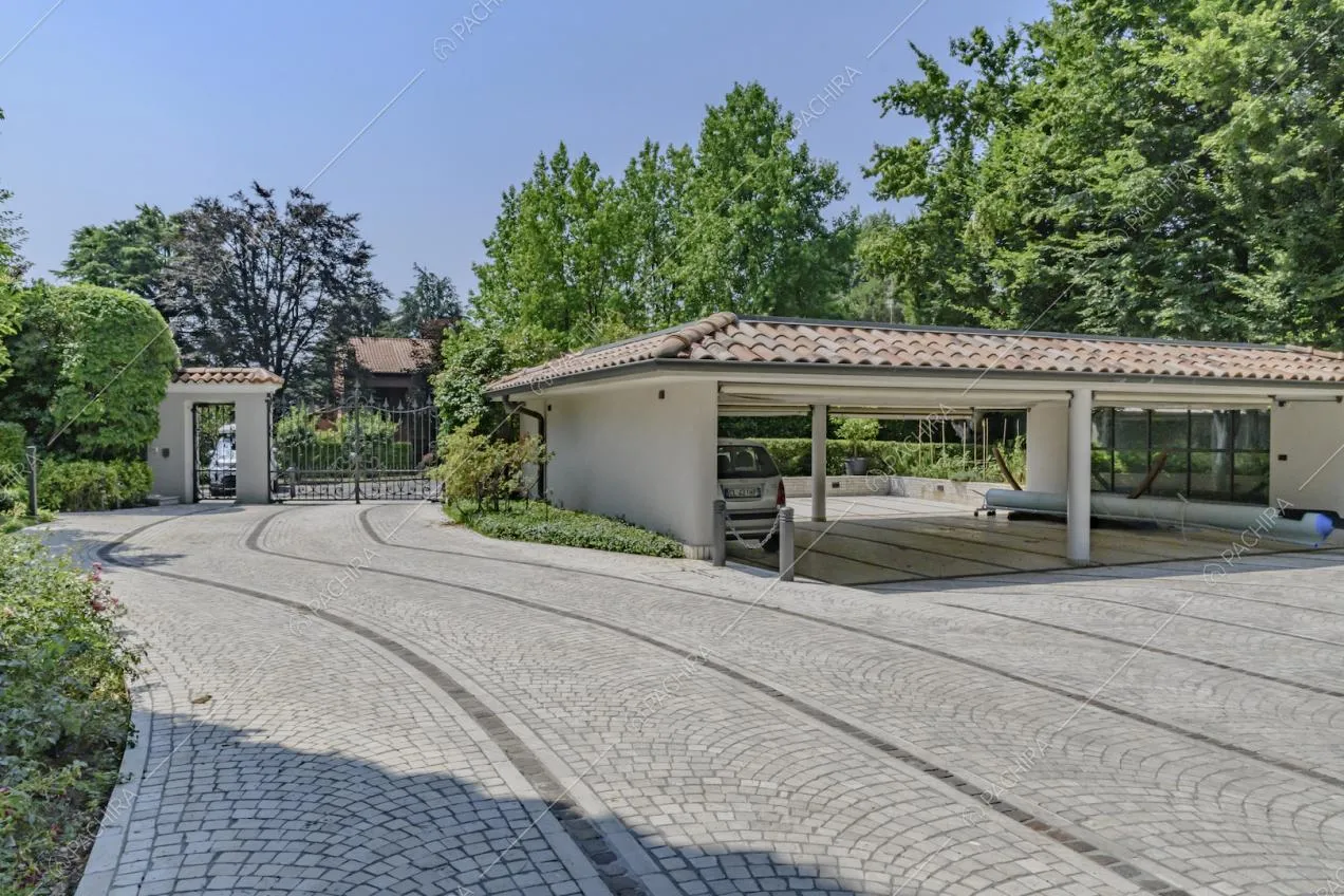 Parcheggio con tettoia e pavimentazione in sampietrini negli esterni della villa