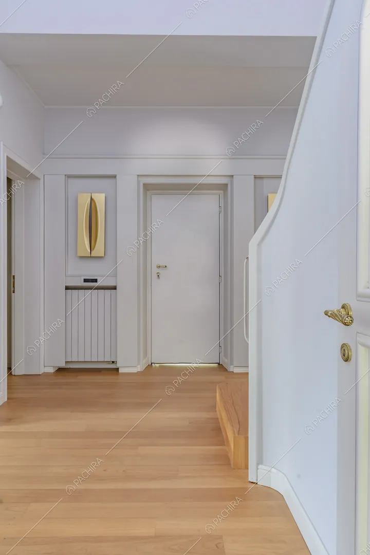 Atrio con pavimento in parquet, pareti bianche e scale