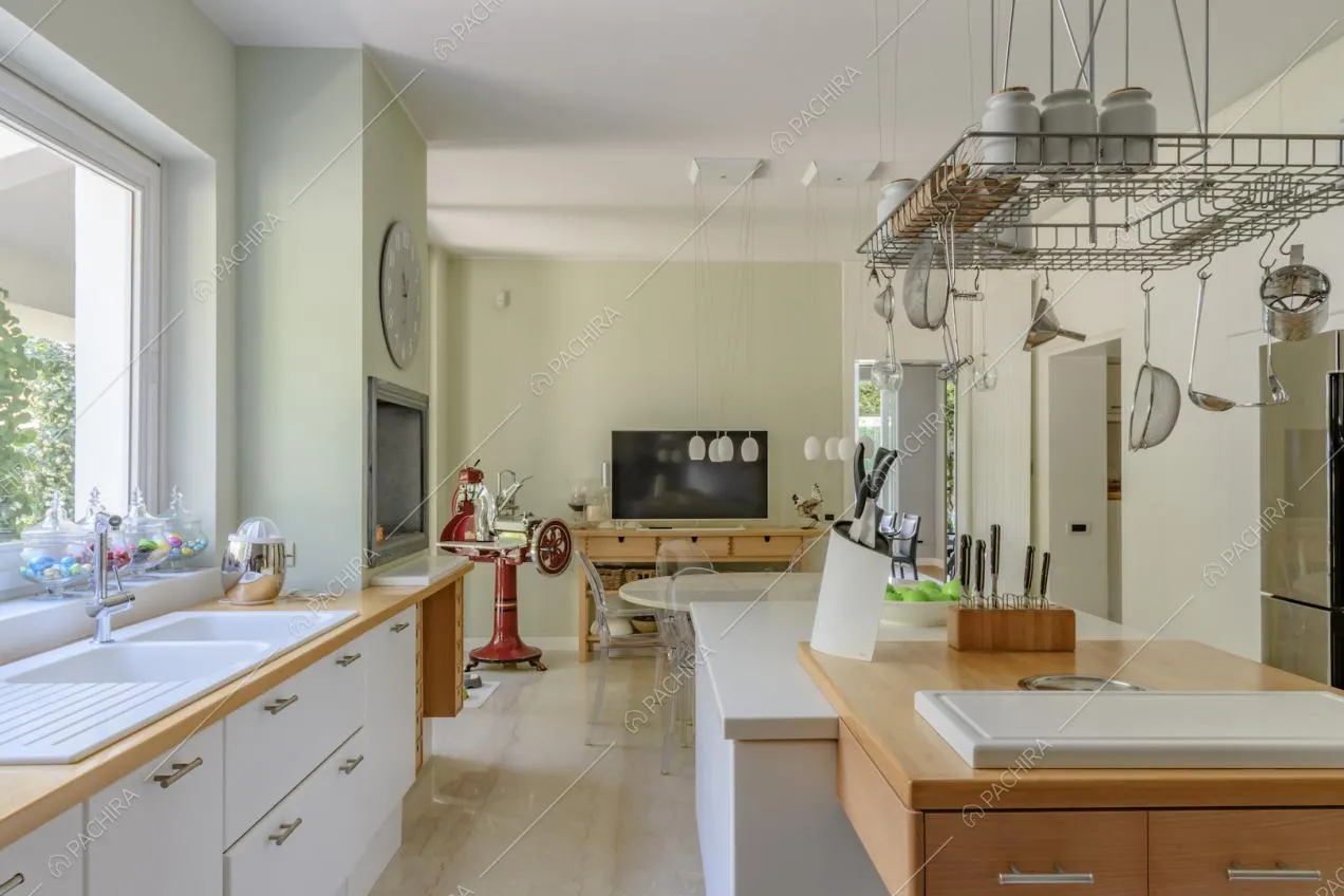 Dall'isola bianca della cucina con tagliere vista sul tavolo da pranzo rotondo
