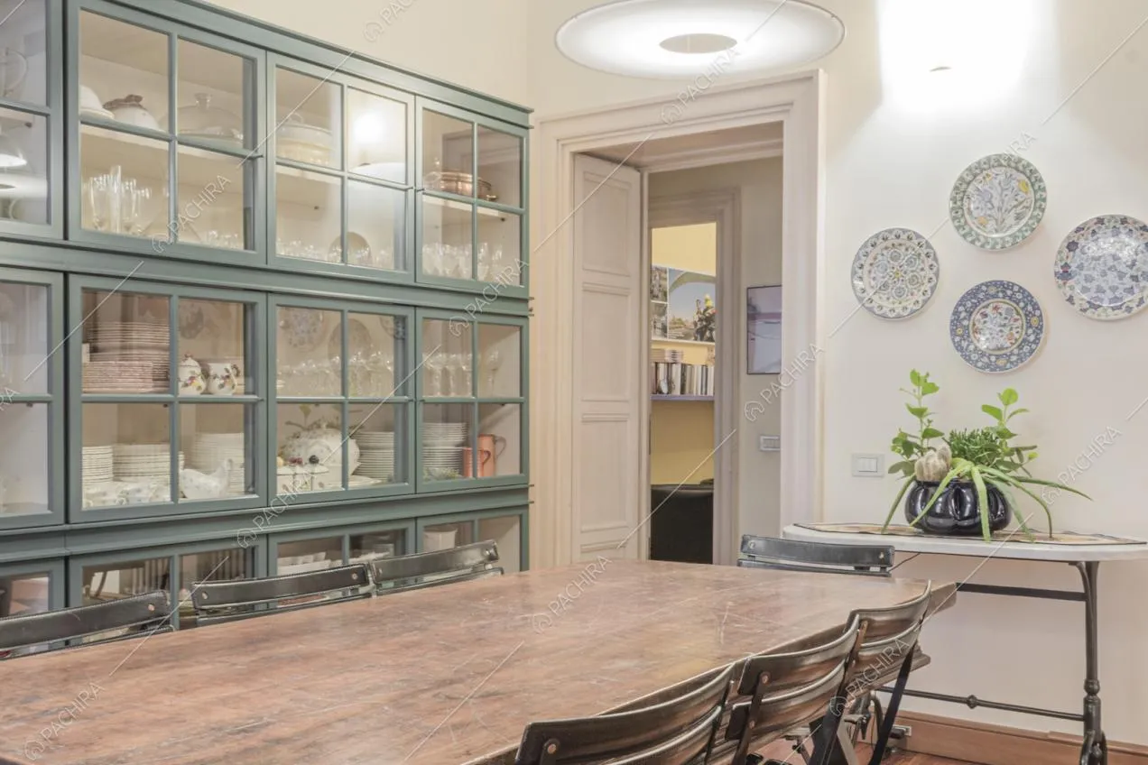 Tavolino vintage, credenza e piatti decorativi appesi alla parete