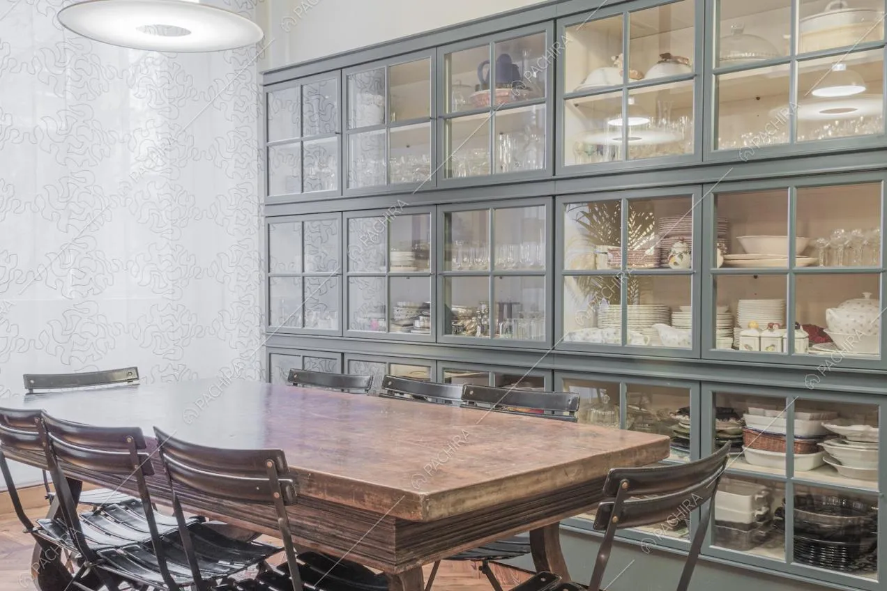 Grande credenza in stile industriale con ante in vetro e stoviglie