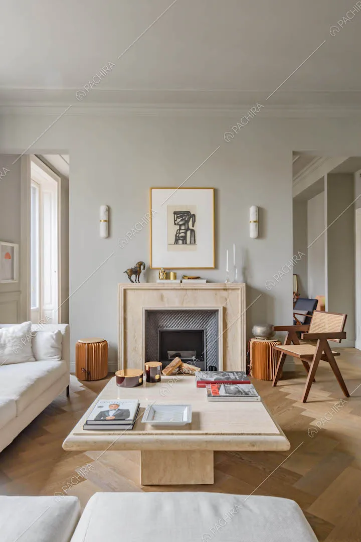 Salotto con pavimento in parquet, divano bianco angolare, tavolino in marmo e camino