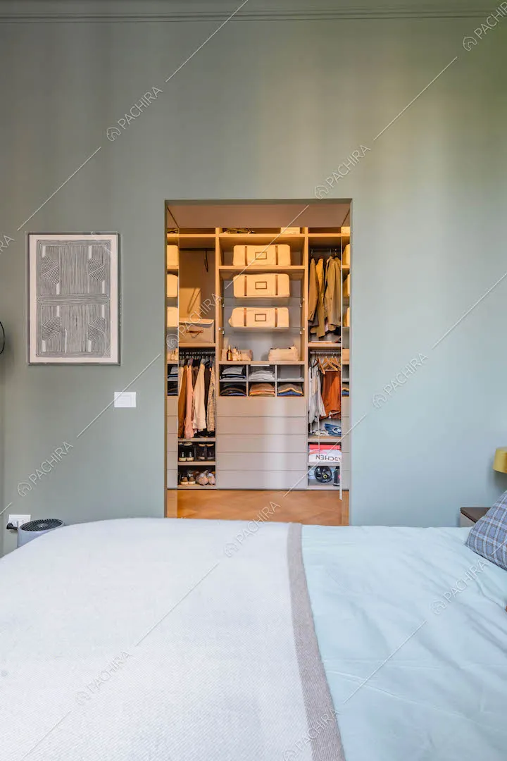 Dal letto matrimoniale della camera con boiserie sul soffitto vista sulla cabina armadio