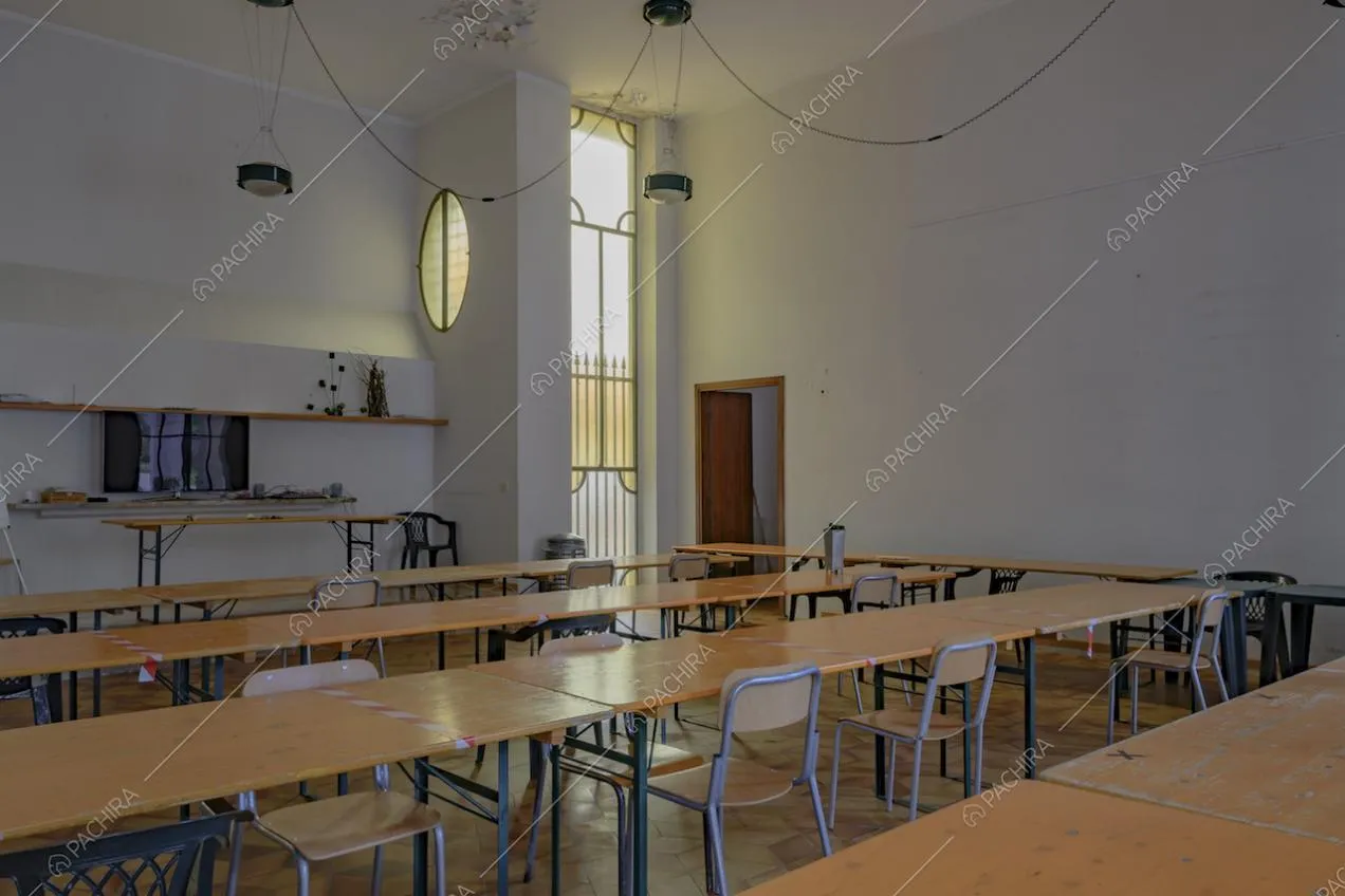 Lunghi tavoli in legno chiaro con sedie da scuola