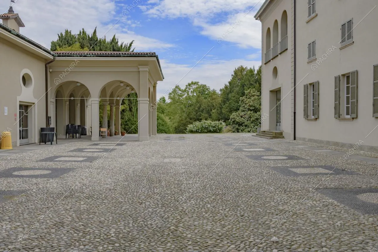 Pavimento in ciottolato e portico nel cortile della villa