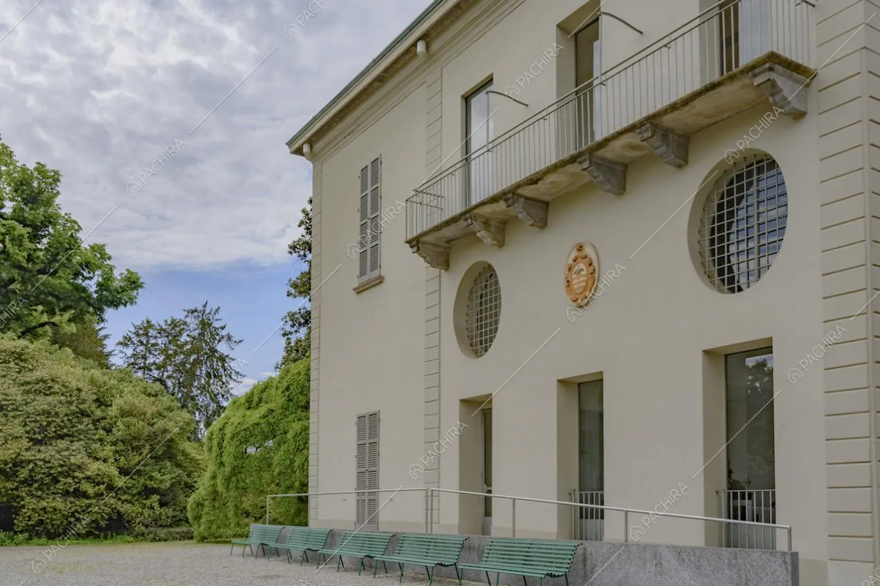 Panchine all'esterno della villa e alberi nel giardino