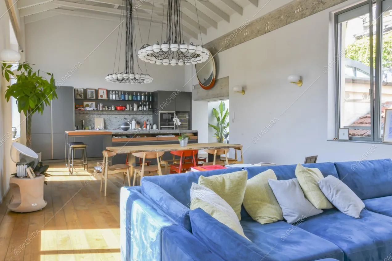 Zona giorno con cucina a parete, tavolo da pranzo e travi a vista