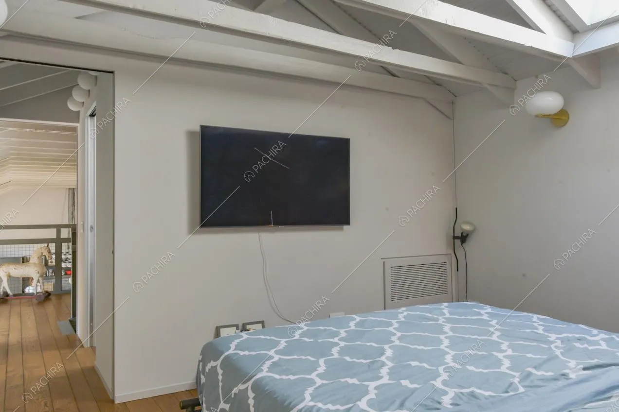 Travi a vista bianche e televisione nella camera da letto