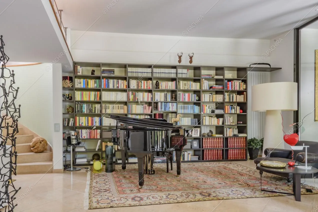 Grande libreria lungo la parete e pianoforte a coda nero