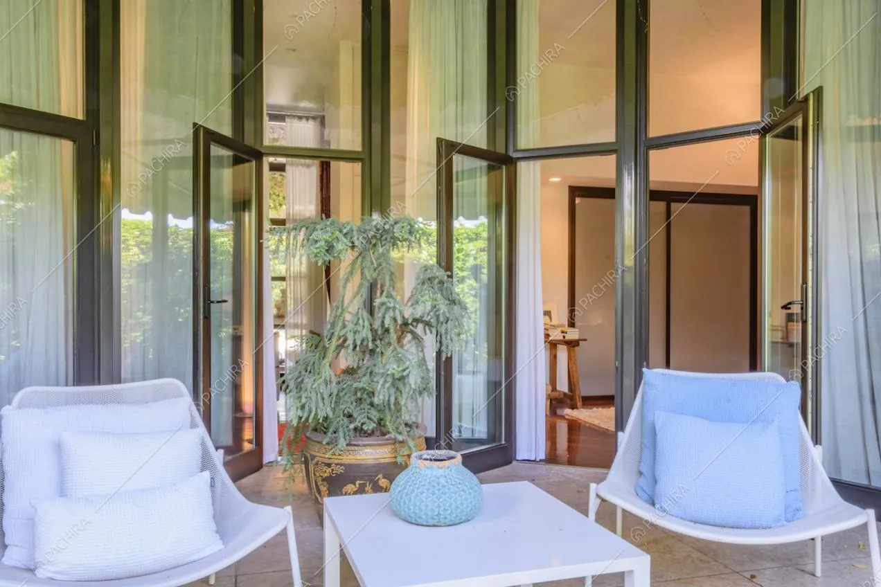 Area relax con sedie e tavolino e grandi porte finestre